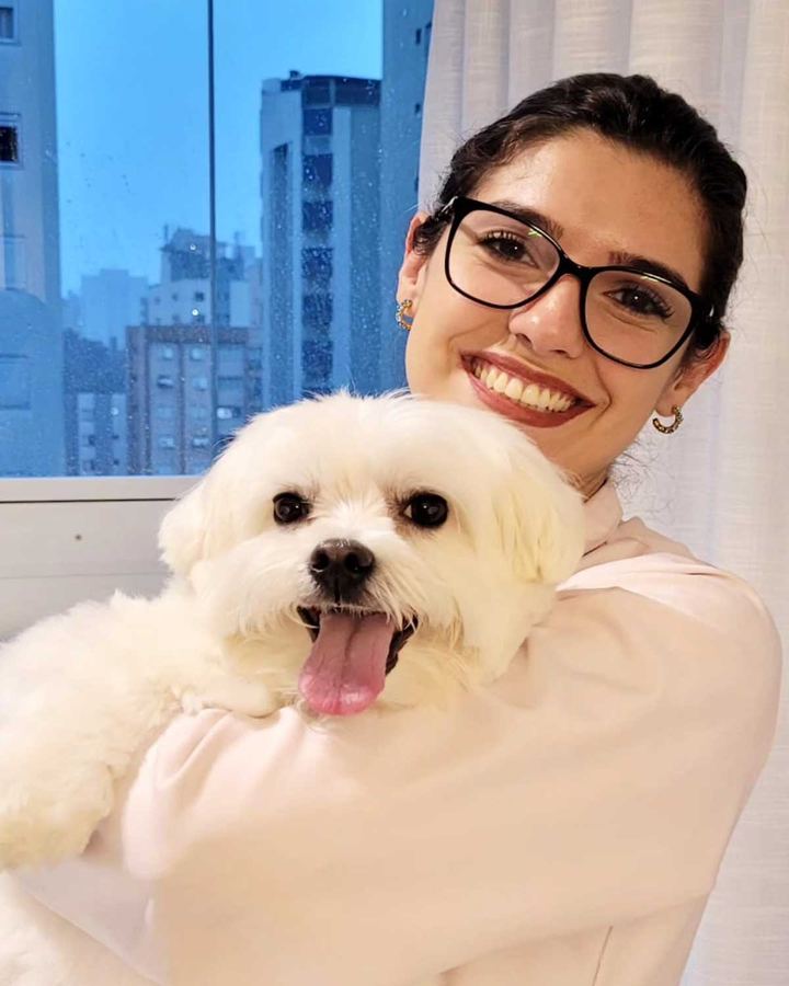 M.V. Priscilla Bolt, endocrinologista veterinária, abraçando um cão Maltês